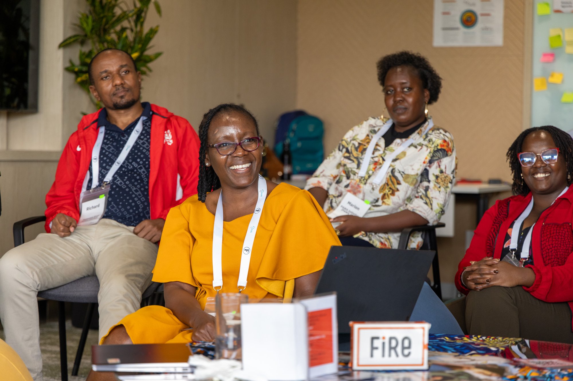 4 people sit during a FIRE training in Nairobi, smiling at someone off frame