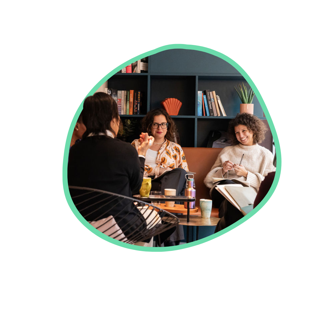 Two women sit on a coach facing Spring Coaching Lead