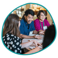 Three program participants talking around a table