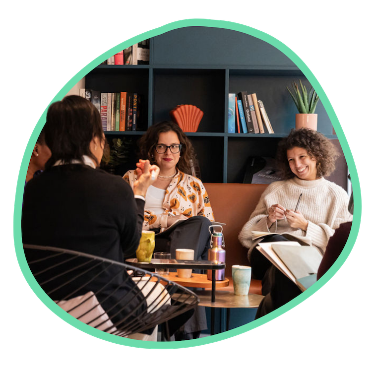 Two women sit on a coach facing Spring Coaching Lead