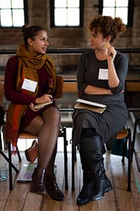 Two excited executive women actively sharing opinions in Collaboration program dynamics