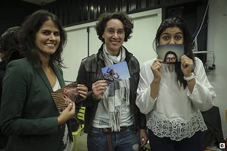 FIREThree women participating in the FIRE program holding photographs in front of the camera, very smiling and happy