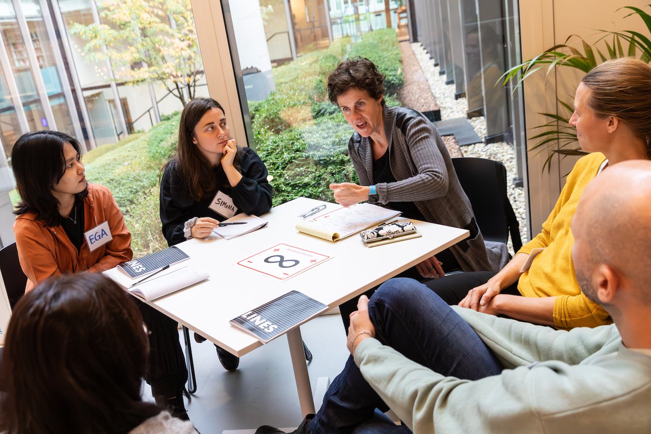 Spring Co-CEO Ellen Sprenger is at a table talking to a group of participants