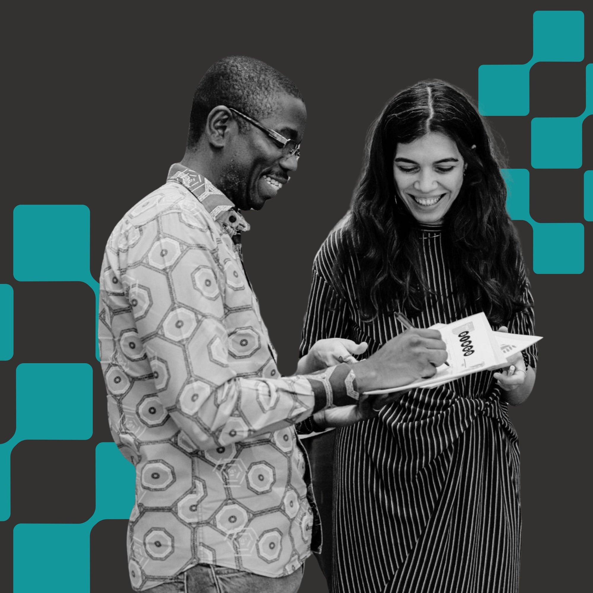 2 people smiling and writing down on a piece of a paper