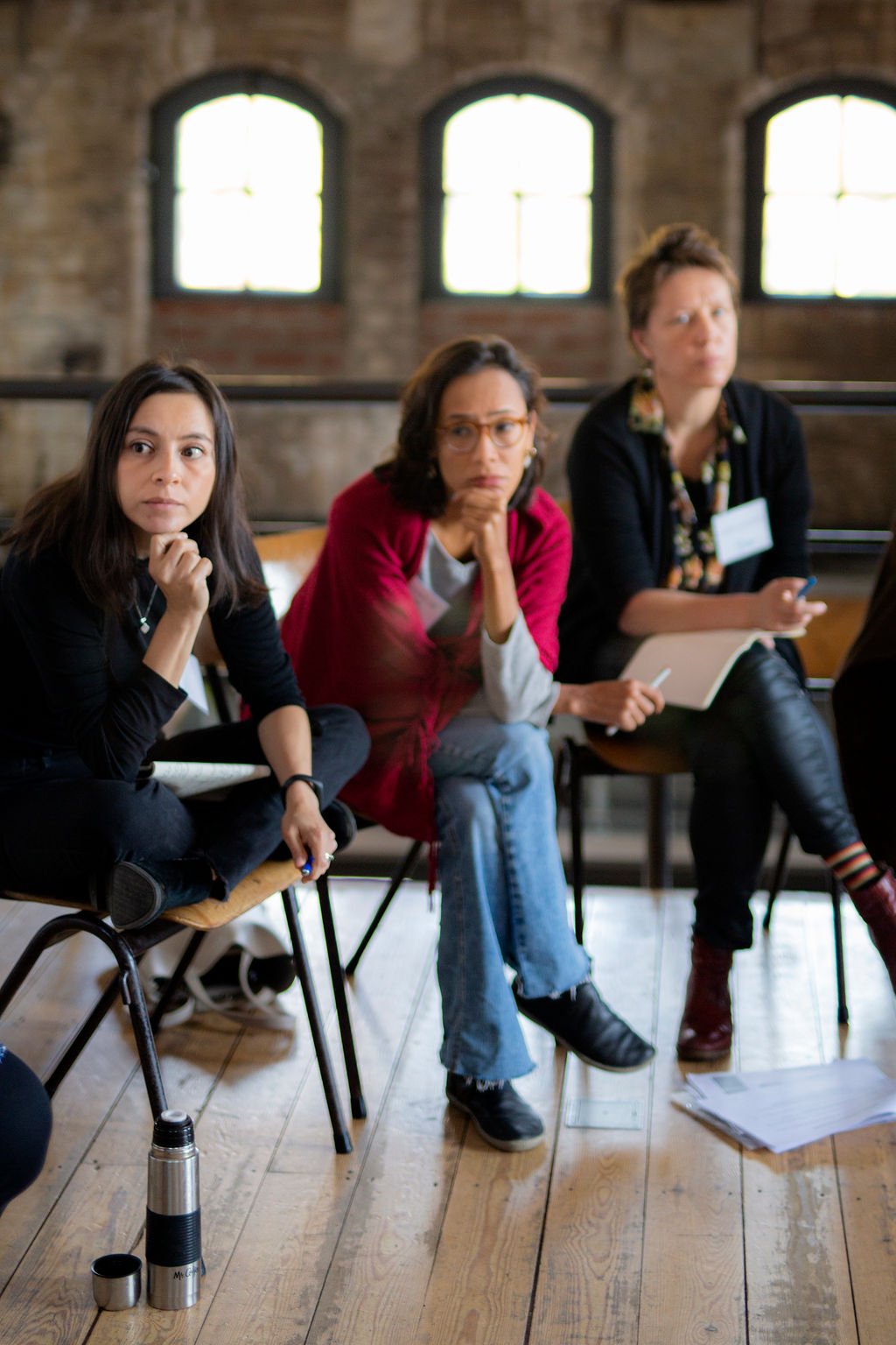 Three women sit and pay attention during a Reimagining Collaboration training in Amsterdam