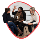 Two women and one man sit together during a training having a lively conversation